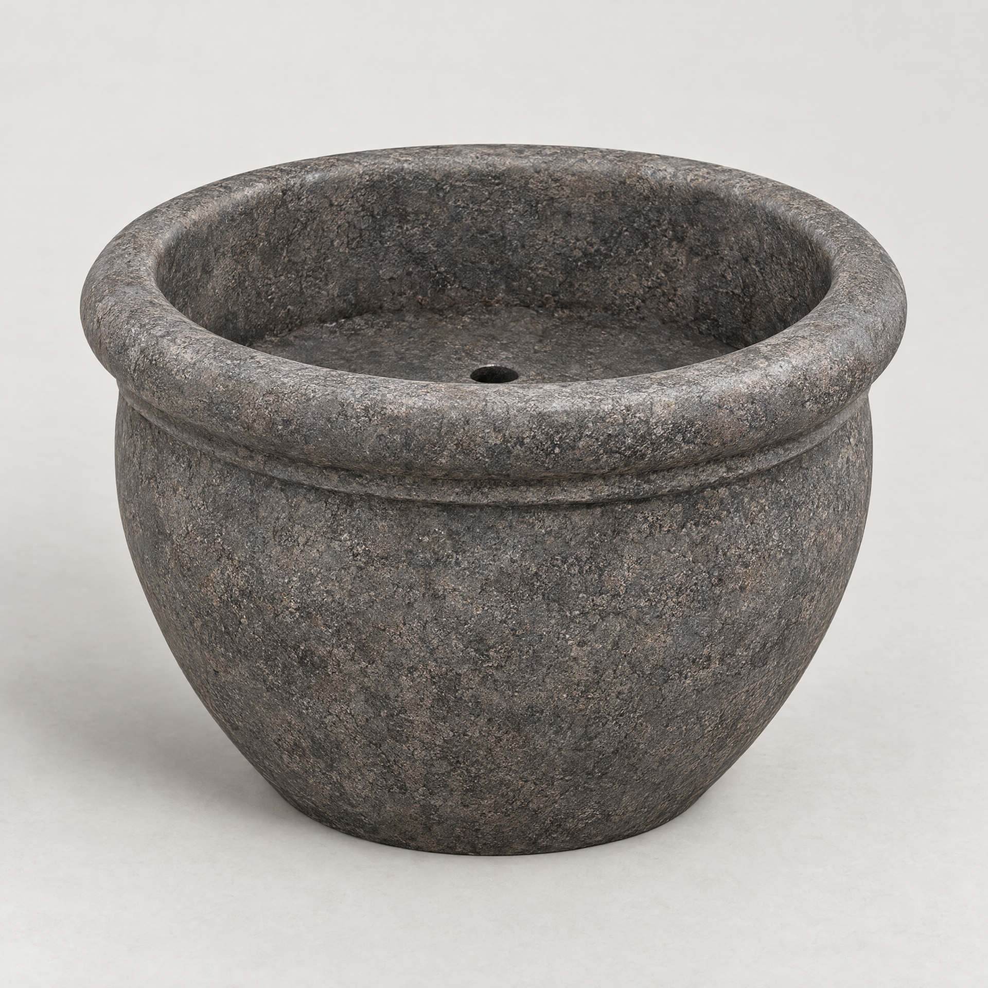 AI-generated concept image of an empty round charcoal stone-look decorative planter with a rolled rim