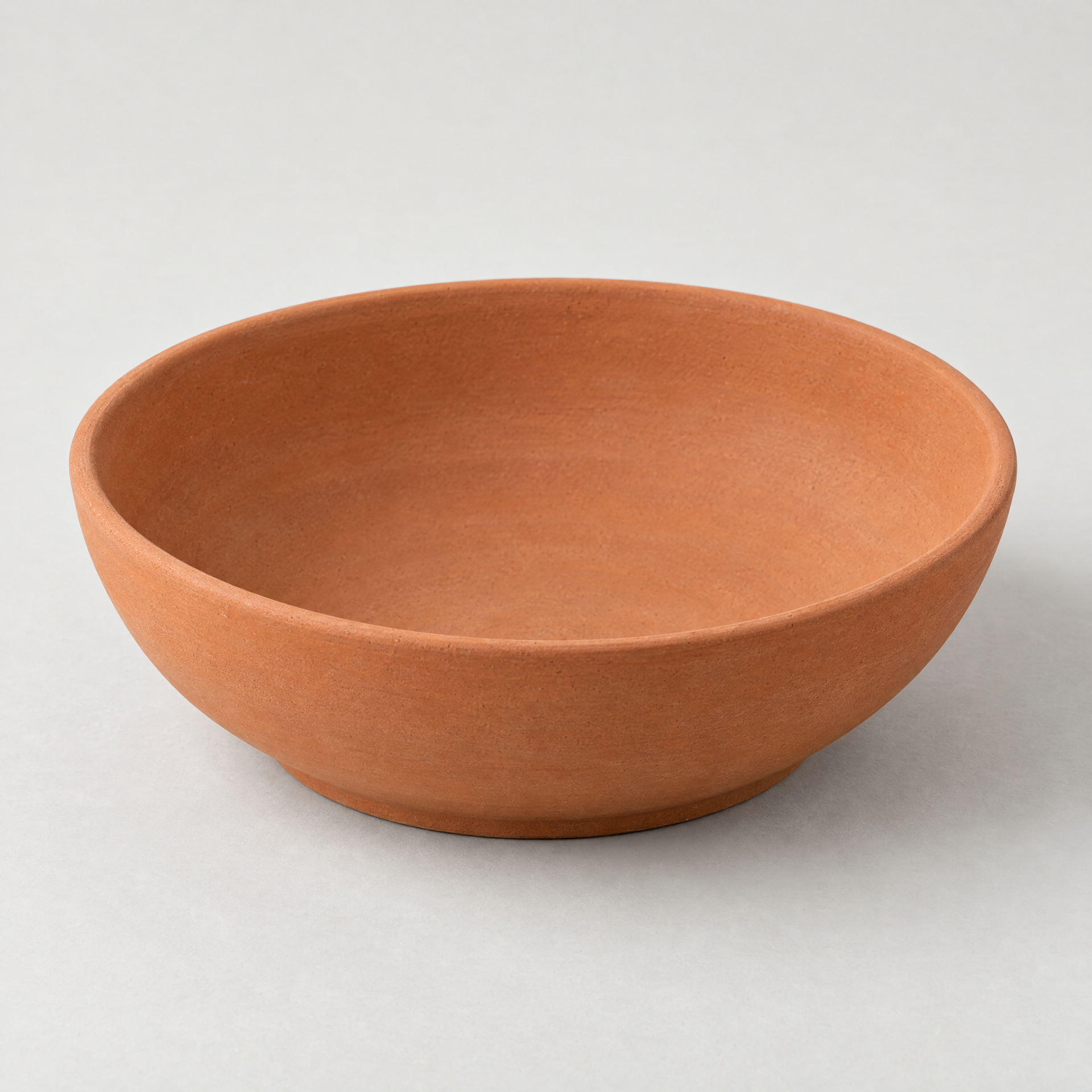 AI-generated concept image of an empty shallow warm terracotta-look decorative display bowl